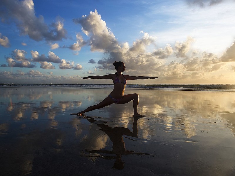 Person macht Yoga im Watt