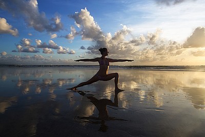 Person macht Yoga im Watt