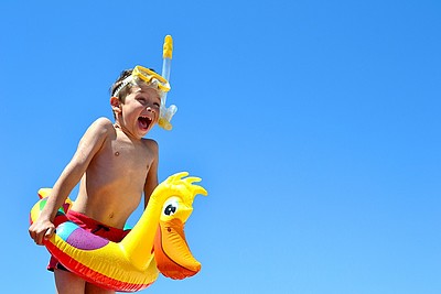 Kind mit Schwimmring und Taucherbrille