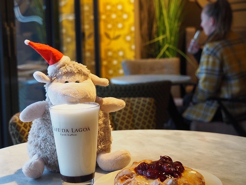 Deichschaf sitzt in einem Café und ist Kuchen