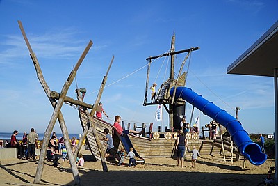 Kinder spielen bei guten Wetter auf dem Spielhaus beim Strandhaus Döse