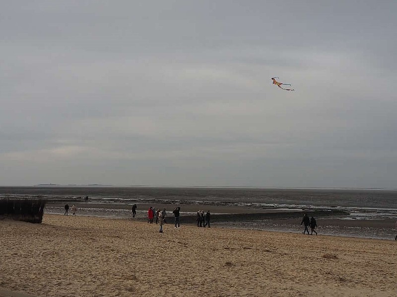 Strand in Cuxhaven mit einem Drachen in der Luft