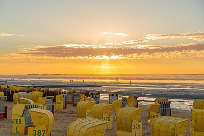 Sonnenuntergang und gelbe Strandkörbe