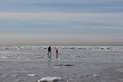 Zugefrorene Nordsee mit Personen auf dem Eis
