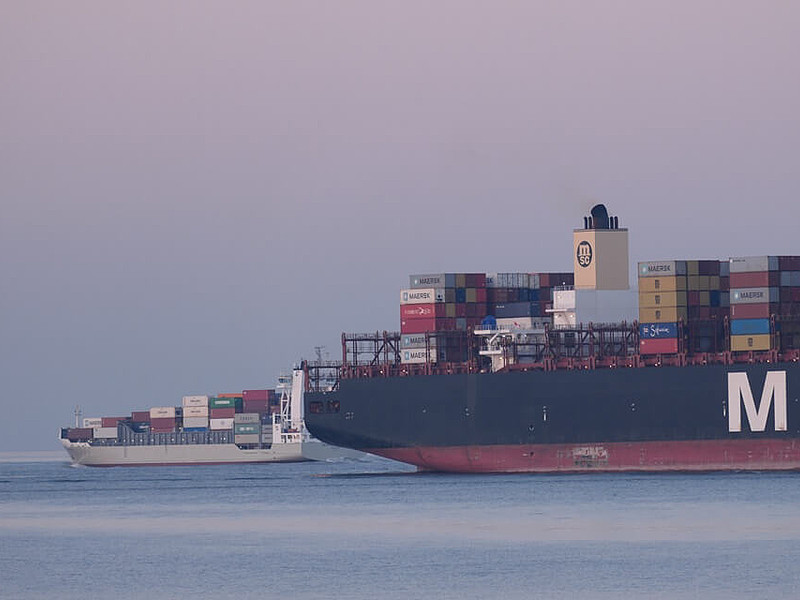 Zwei Containerschiffe auf dem Weltschifffahrtsweg in Cuxhaven bei Sonnenuntergang