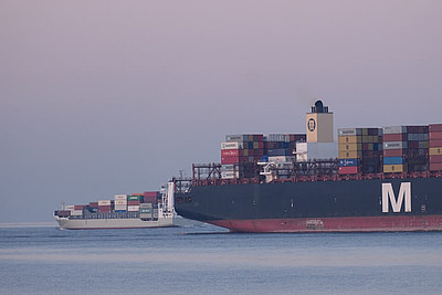 Zwei Containerschiffe auf dem Weltschifffahrtsweg in Cuxhaven bei Sonnenuntergang