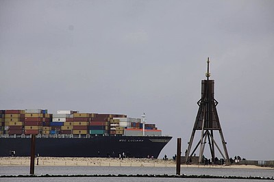 Containerschiff fährt an der Kugelbake von Cuxhaven vorbei