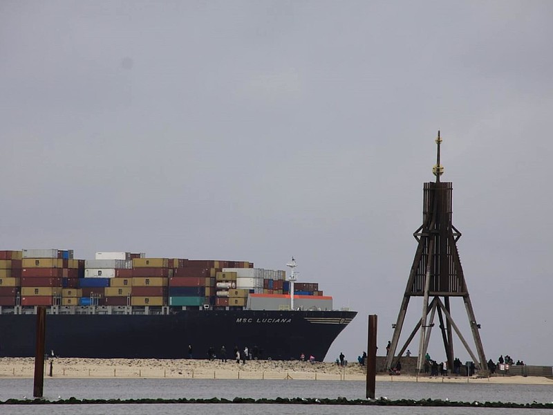 Containerschiff fährt an der Kugelbake von Cuxhaven vorbei