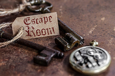 Zwei Schlüssel mit einem Schild auf dem der Schriftzug Escape Room steht