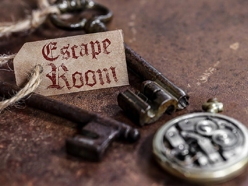 Zwei Schlüssel mit einem Schild auf dem der Schriftzug Escape Room steht