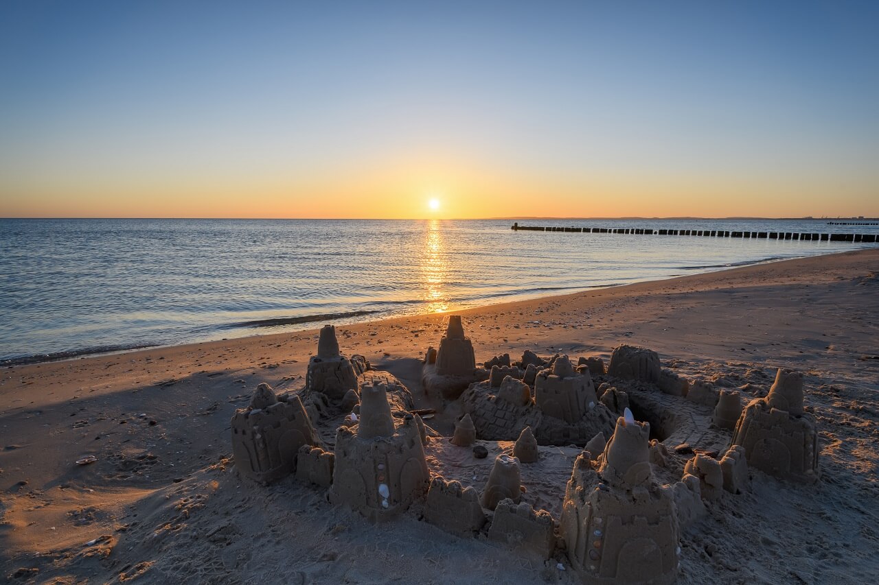 Sandburg am Strand bei Sonnenuntergang