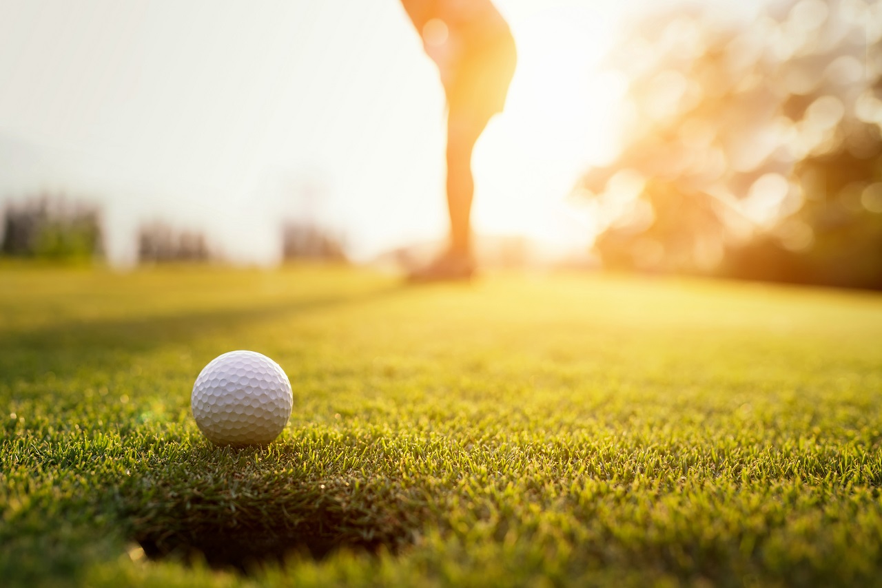 Golfball liegt auf dem Rasen eines Golfplatzes