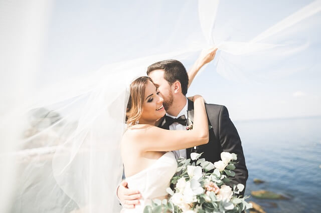 Hochzeitspaar umarmt sich am Strand