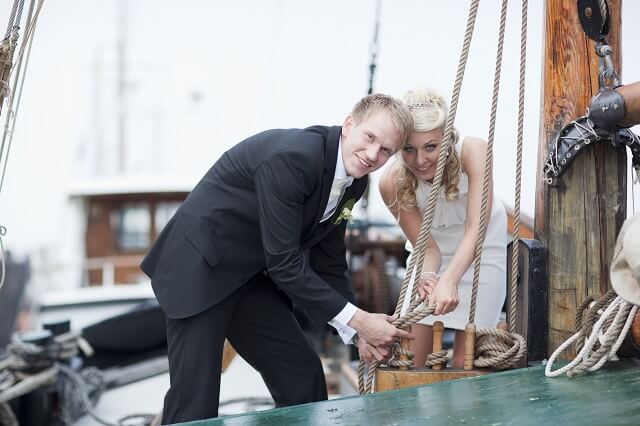 Hochzeitspaar spannt Seil auf einem Segelschiff