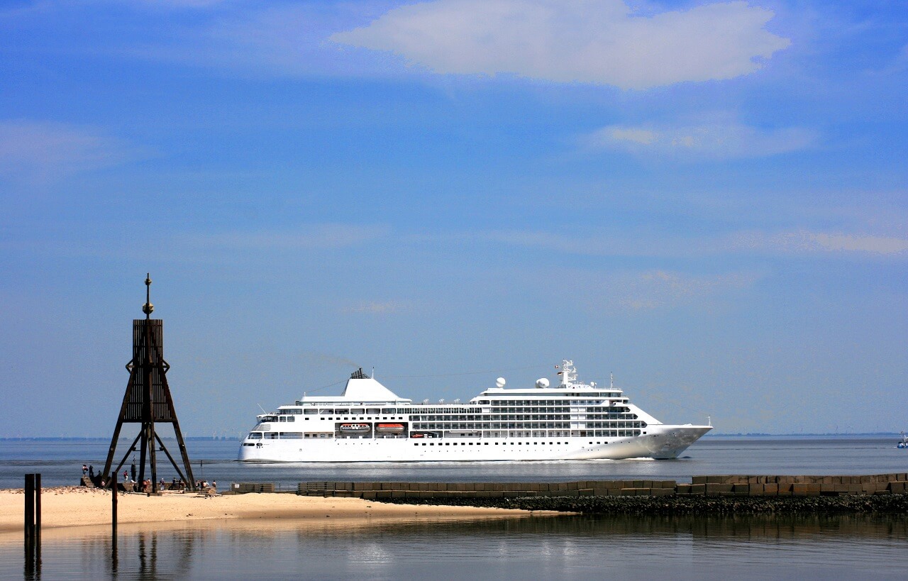 Kreuzfahrtschiff fährt über die Elbe vorbei an der Kugelbake in Cuxhaven