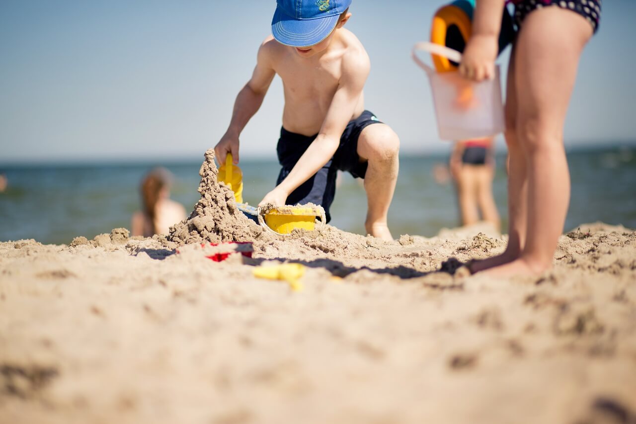 Kinder im Urlaub spielen am Strand