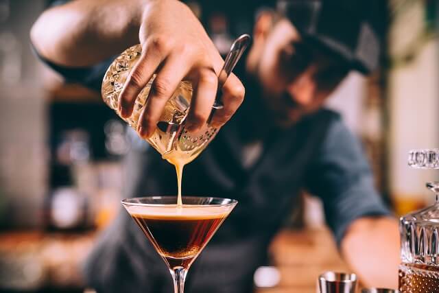 Barkeeper schenkt Getränk an einer Bar in einer Kneipe ein