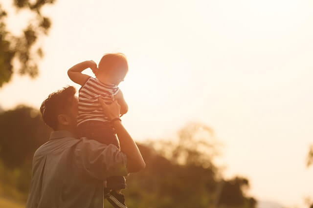 Vater mit Sohn bei Sonnenuntergang