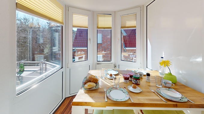 Ein gedeckter Frühstückstisch im Erker der Ferienwohnung Gorck Fock - 11