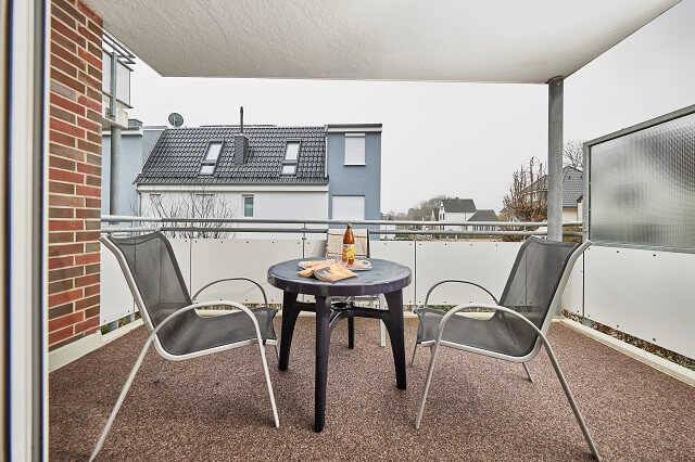 Überdachte Terrasse mit Gartenmöbeln und Blick auf die Straße