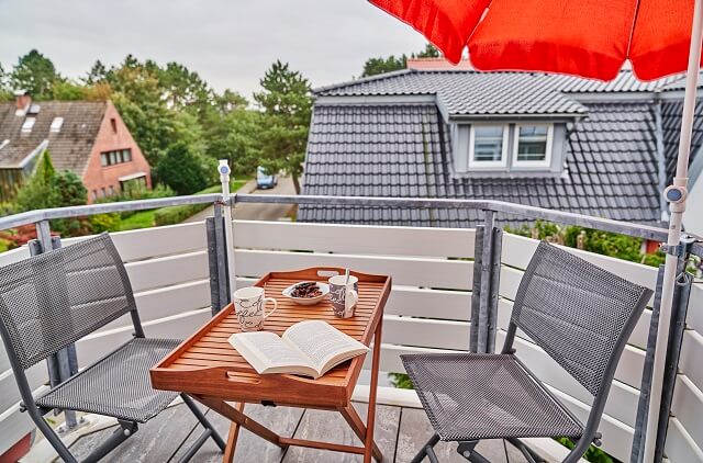 Balkon mit gedecktem Tisch und einem aufgeschlagenen Buch