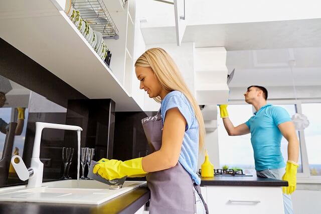 Zwei Personen reinigen eine Küche